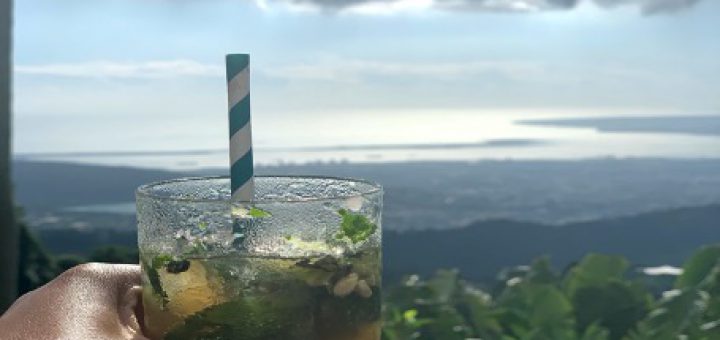 Enjoying a mojito while having lunch at a hotel in the Blue Mountains, Jamaica’s longest and highest mountain range, with Jamaica’s south eastern coastline as a backdrop.