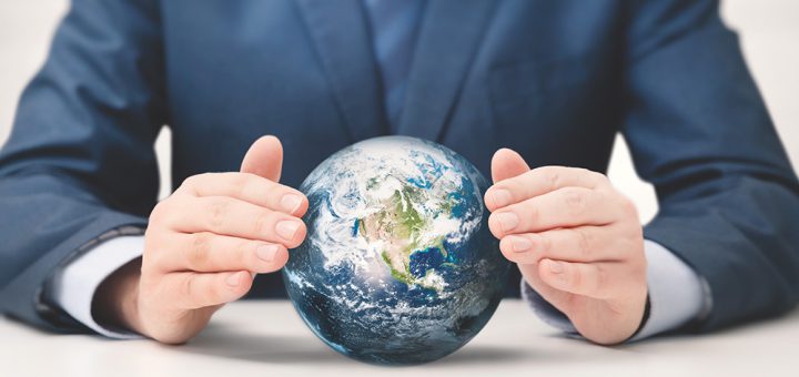 Businessman in suit protects the planet earth, taking care of the climate. Elements of this image furnished by NASA (https://www.jpl.nasa.gov/edu/images/activities/blue_marble.jpg)