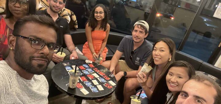Newly connected MBA students unwinding over boba tea and card games.